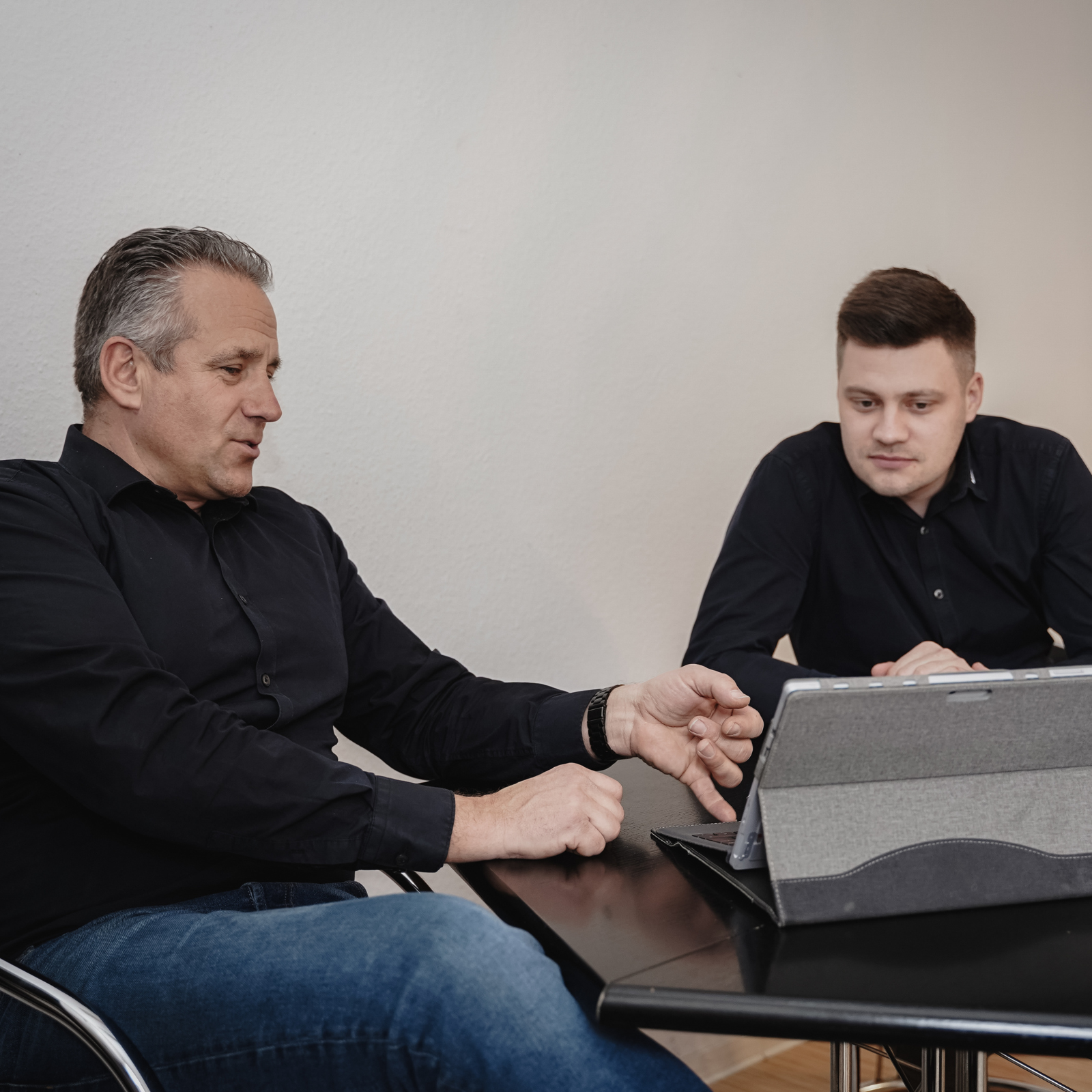 Zwei WENZ-Berater sprechen an einem Tablet über ein Projekt